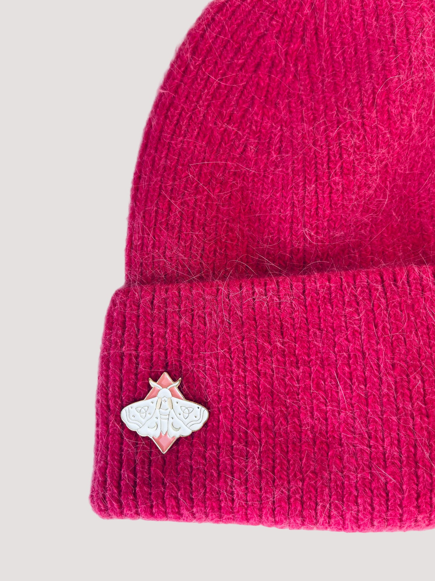 Pink knit angora pink beanie with an elegant butterfly pin on the side