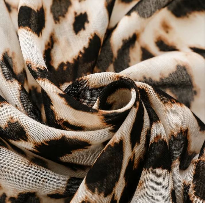 This is a stunning fashion scarf, featuring a bold and modern panther pattern in a beige and sand color crafted from a luxurious blend of natural fabrics, including soft viscose and breathable cotton, this scarf offers both comfort and style.