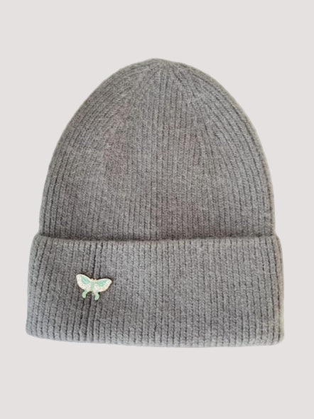 Gray knit angora beanie in silver gray color with a butterfly emblem or pin for cold days