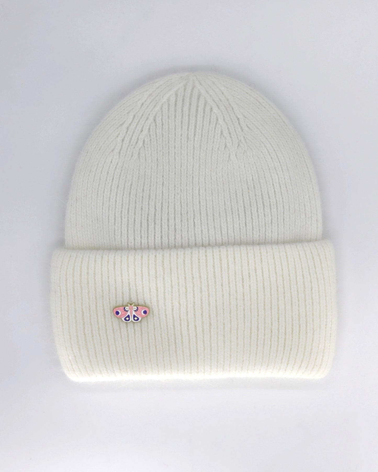 A snow white colored beanie hat made from a blend of angora and wool, displayed against a neutral background.