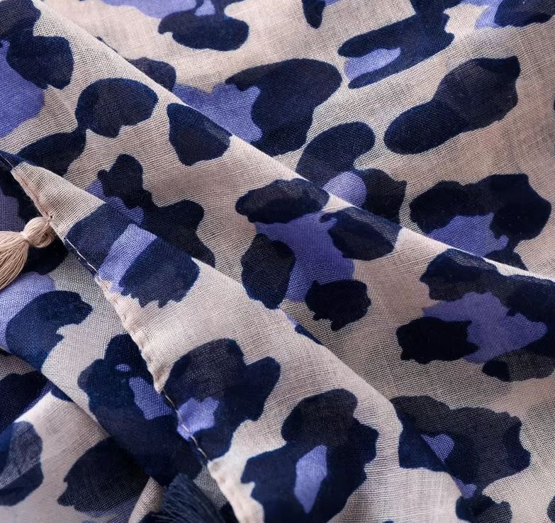 This is a stunning fashion scarf, featuring a bold and modern panther pattern in a fresh lilac and navy color combination crafted from a luxurious blend of natural fabrics, including soft viscose and breathable cotton, this scarf offers both comfort and style.
