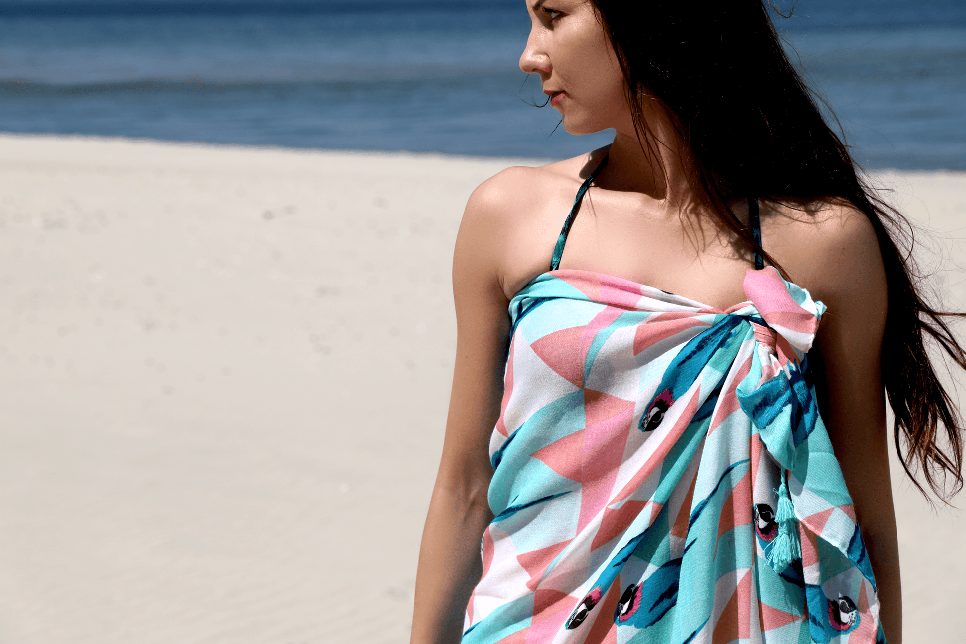 This a soft XL-size viscose beach pareo and scarf for women with trendy tassels in modern geometric and animal-parrot print in turquoise and pink to give you a happy, fresh and modern look. It is a sustainable and vegan PETA certified pareo made from sustainably sourced viscose. This versatile pareo can be used as a skirt, dress, scarf or shawl.